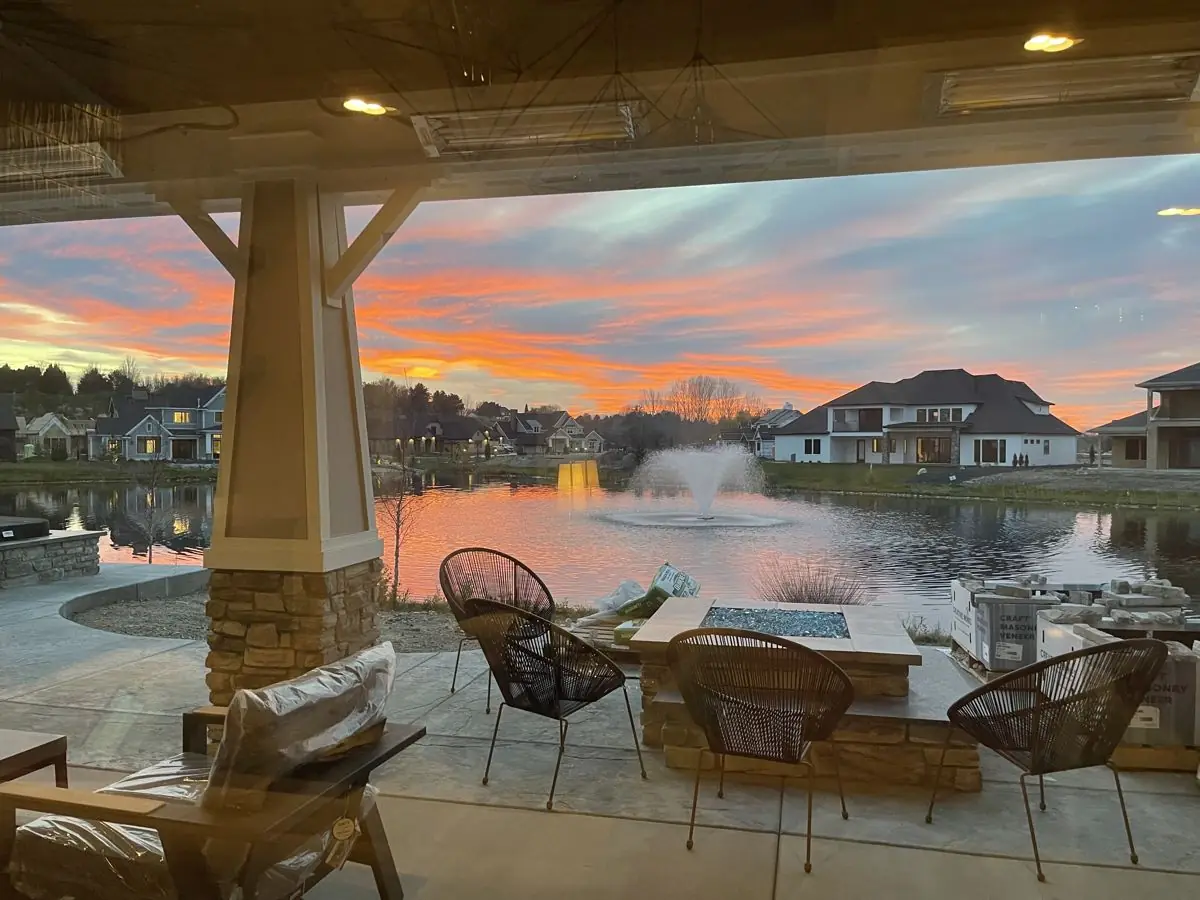Covered patio overlooking a lake and fountain at sunset in Eagle