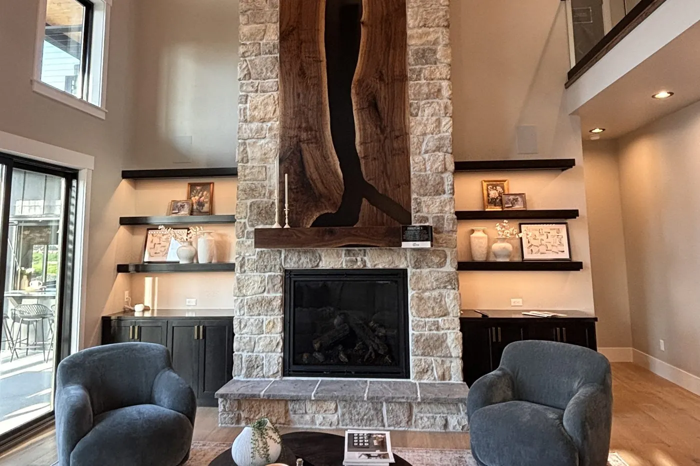 New-build great room with a stone fireplace wall and vaulted wood ceiling