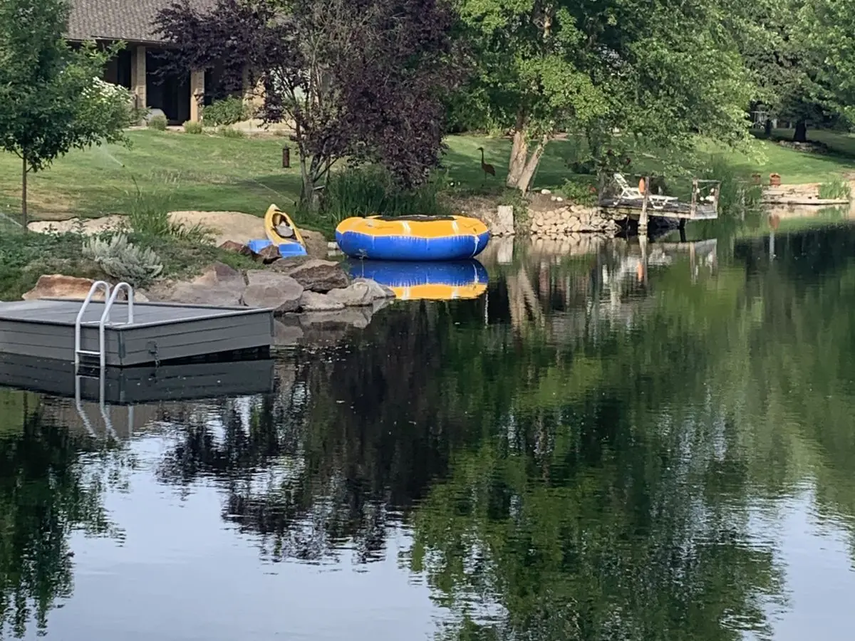 A private pond with a dock and paddleboards