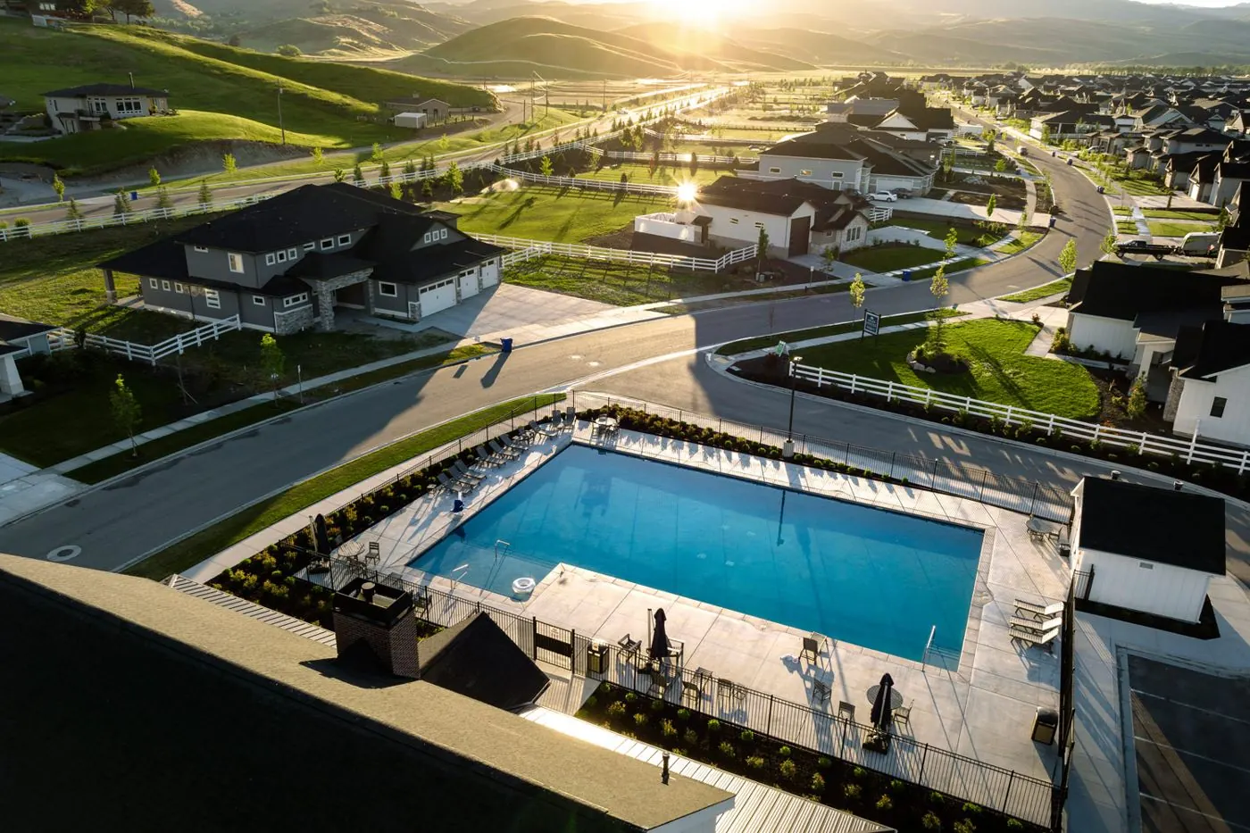 Dry Creek Ranch community pool with white rail fences and the Foothills