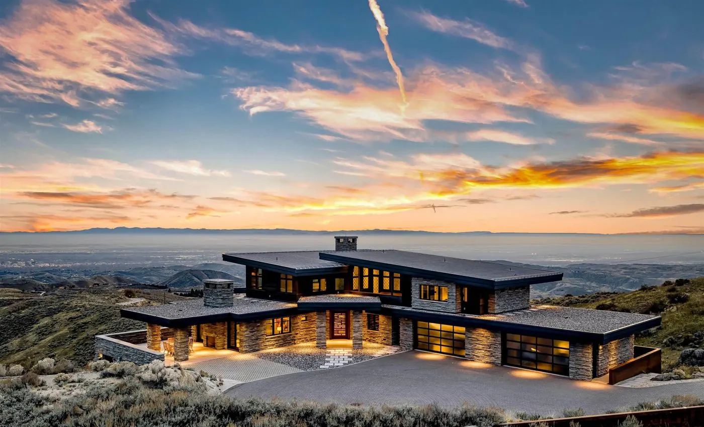 Modern stone home in the Boise Foothills overlooking the valley at sunset
