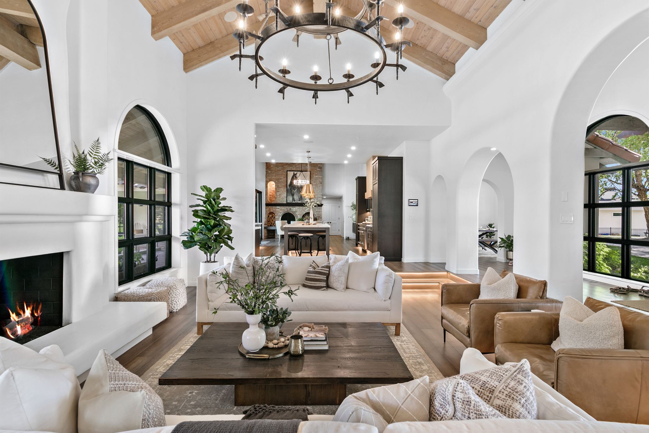 Bright, styled great room with arched windows and neutral furnishings